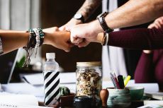 Diverse group of people fist bumping over desk. Free for use under the Pixabay Content License