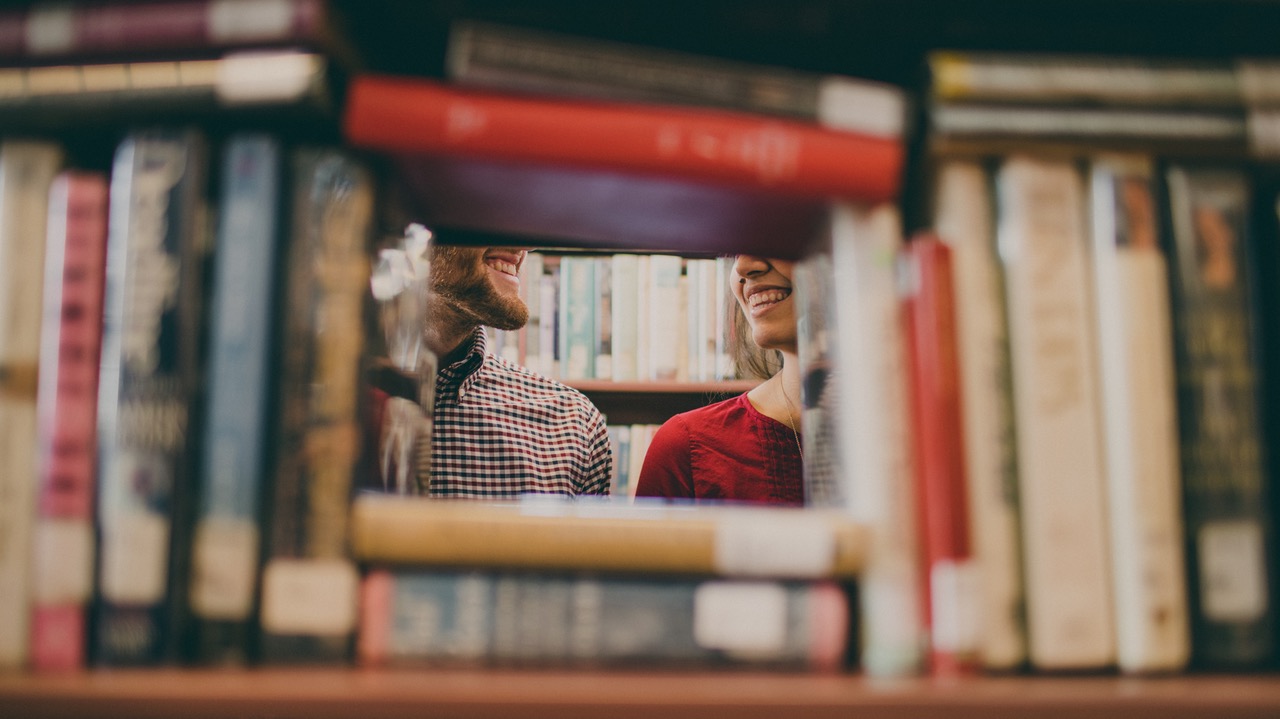 Two people at library behind books - Image provided by author