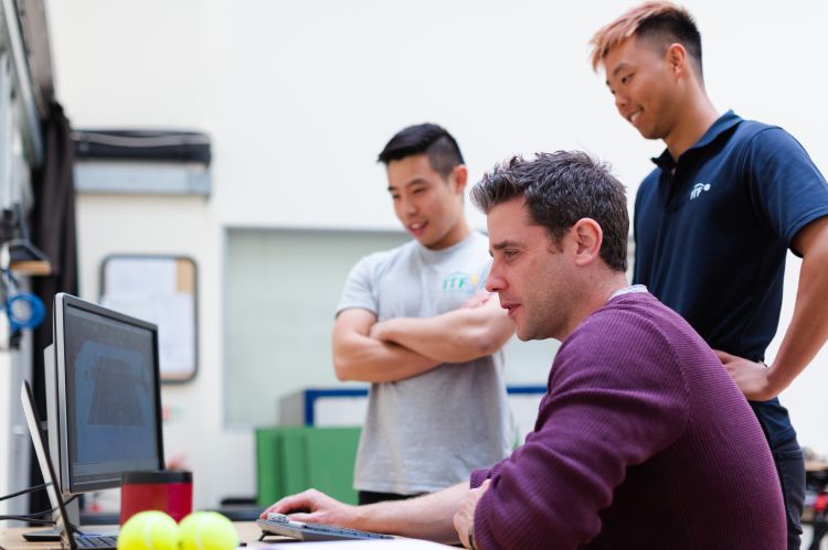 Three developers looking at a computer screen together 