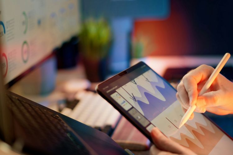 a person using a stylus to draw on a graph on a tablet