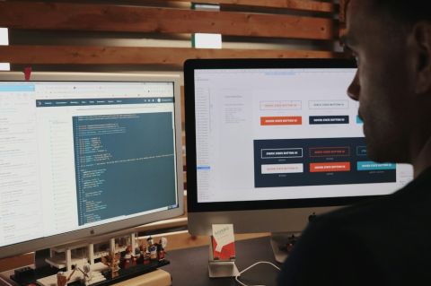 A man using two monitors on a desk